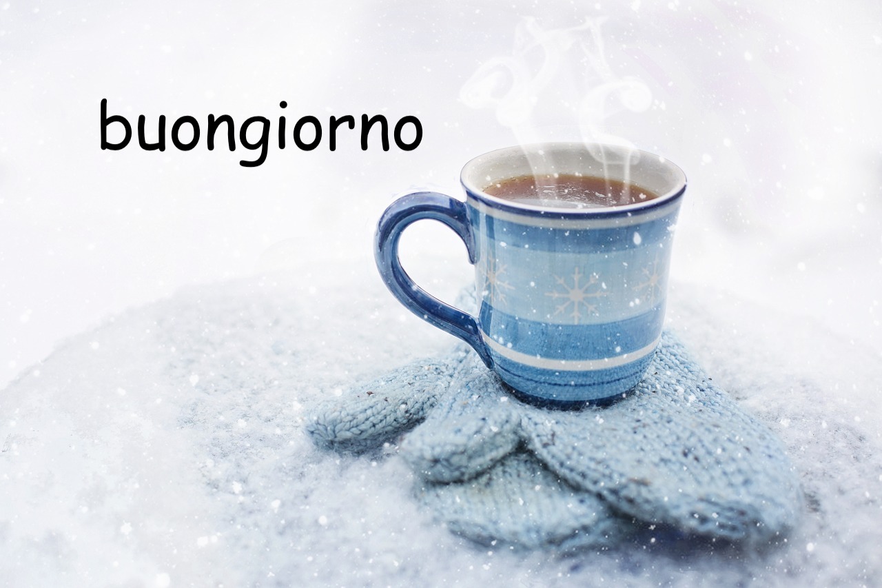 un caffe bollente in mezzo alla neve poggiato su un guanto gelato